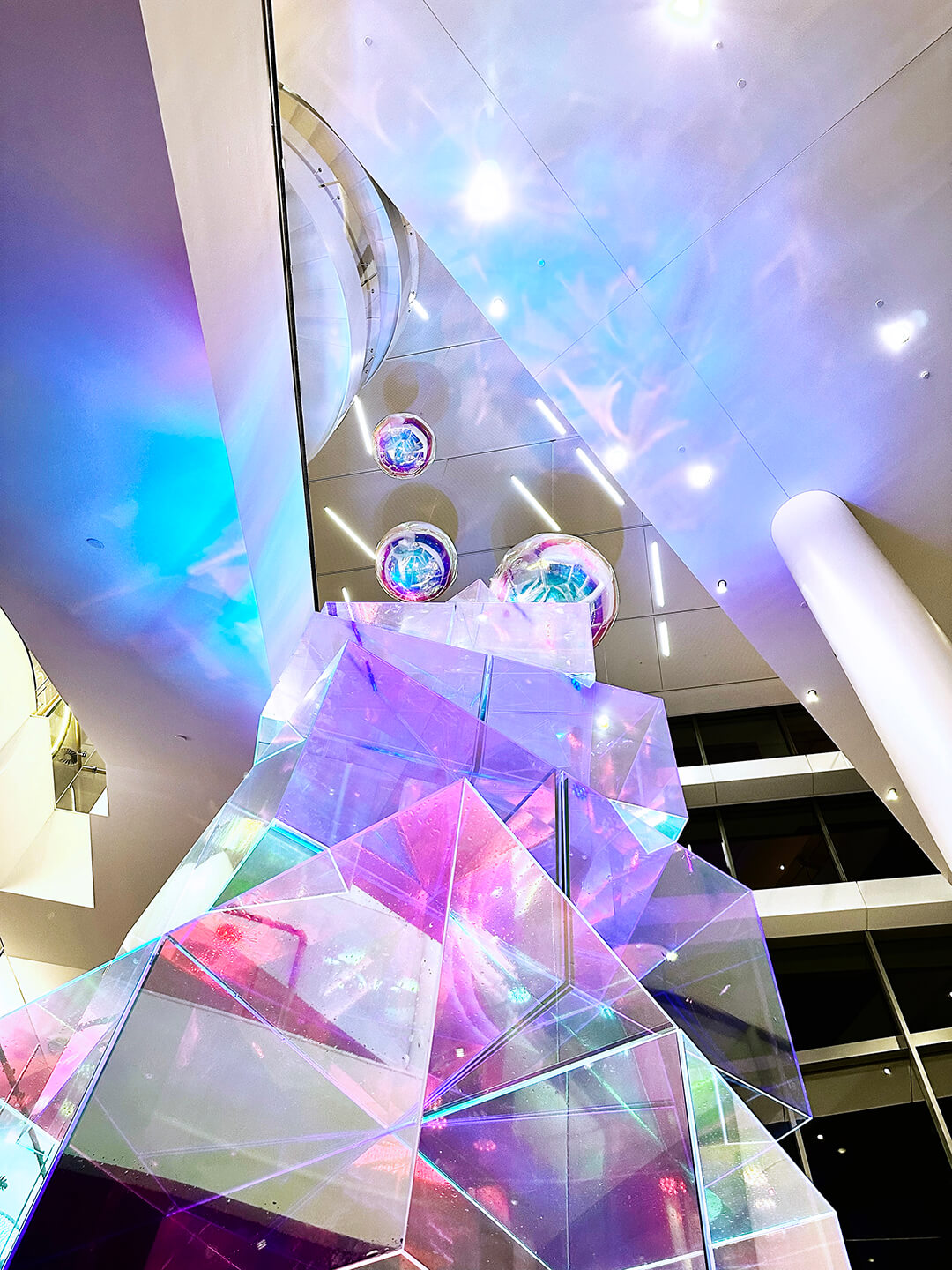 VANDAL Experiential Christmas Campaign for Dexus in the commercial lobby of 50 Bridge Street, Sydney showing dichroic film on escalators and artistic sculpture Christmas tree.