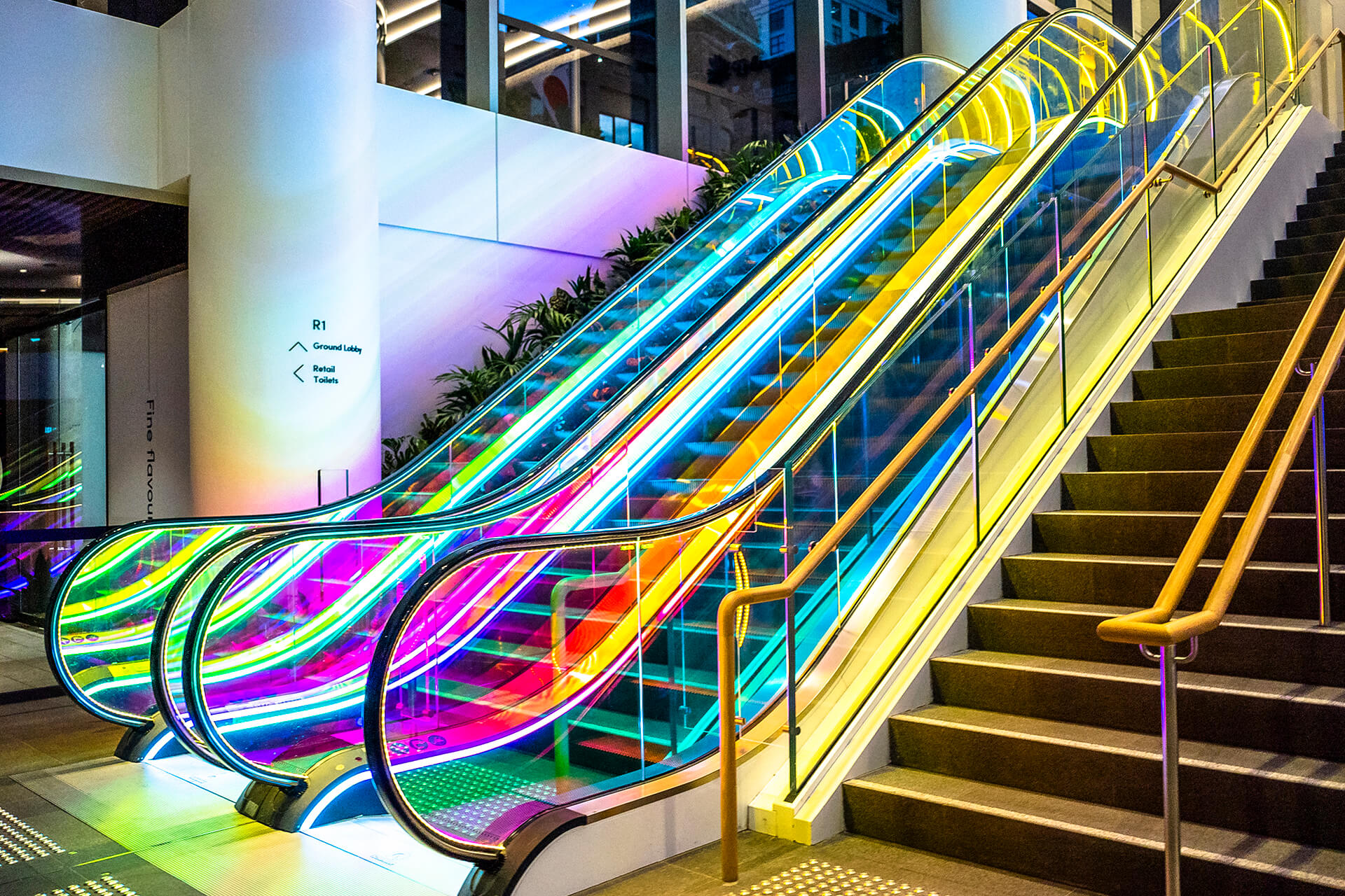 VANDAL Experiential Christmas Campaign for Dexus in the commercial lobby of 50 Bridge Street, Sydney showing dichroic film on escalators and artistic dichroic baubles.