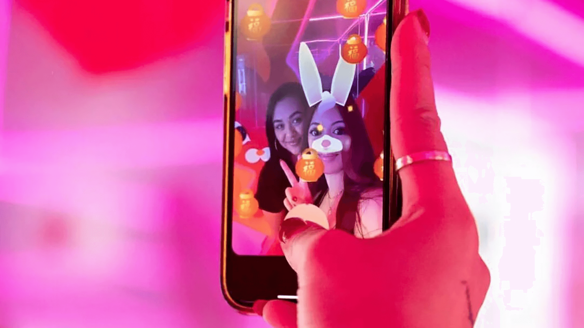 A phone selfie depicting 2 women inside the Lucky Lunar experiential brand activation installation at World Square Sydney for Lunar New Year adorned with VFX rabbit face filters 