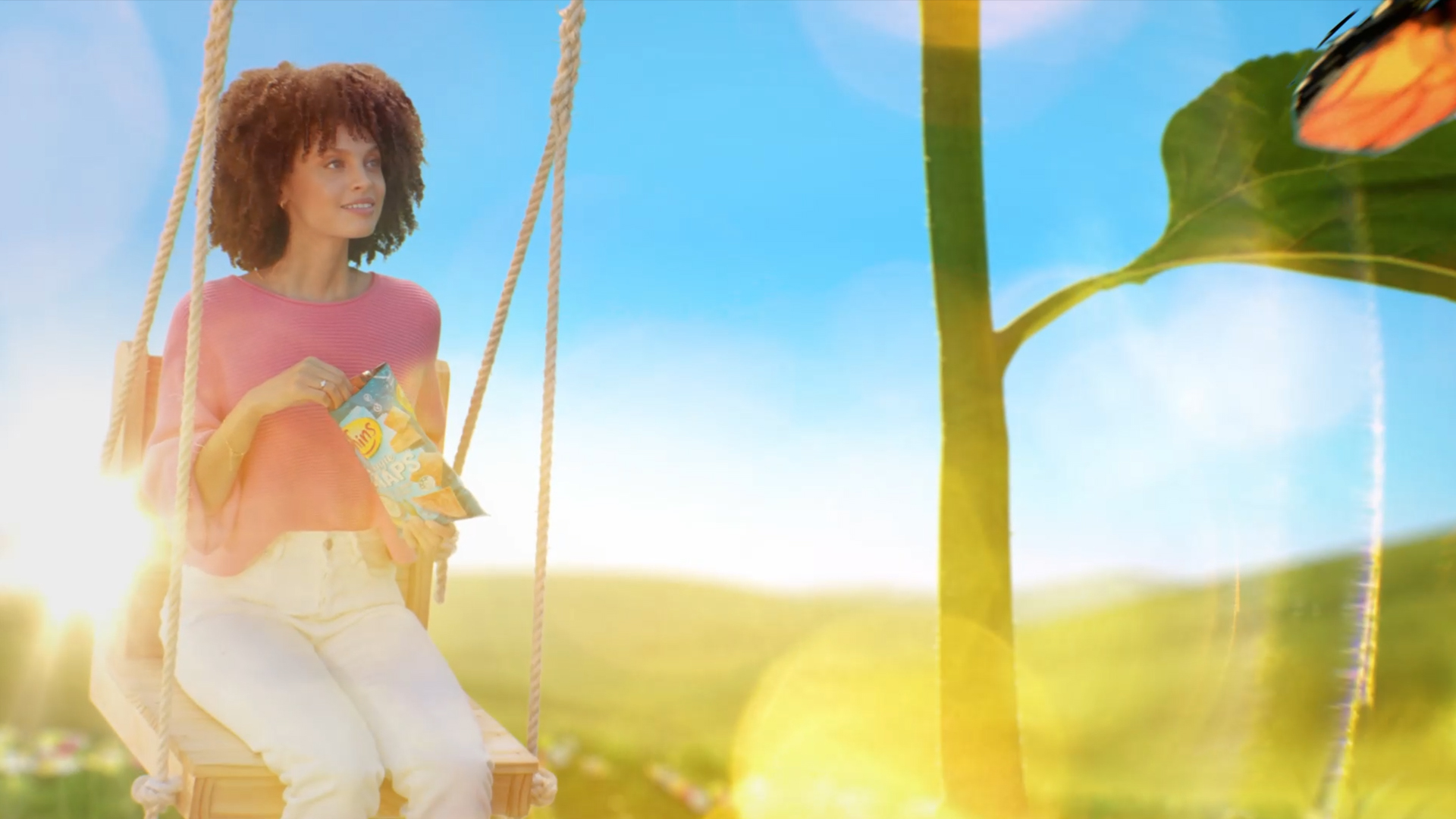Still from the VANDAL produced Thins Veggie Snaps TVC featuring a VFX world with a woman on a swing eating chips