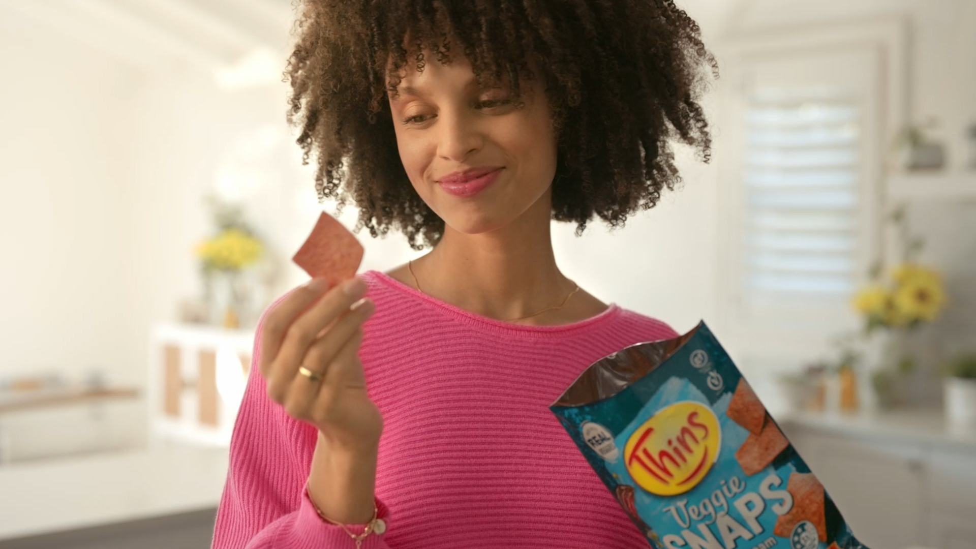Still from the VANDAL produced Thins Veggie Snaps TVC featuring a woman staring at a chip while holding the product bag