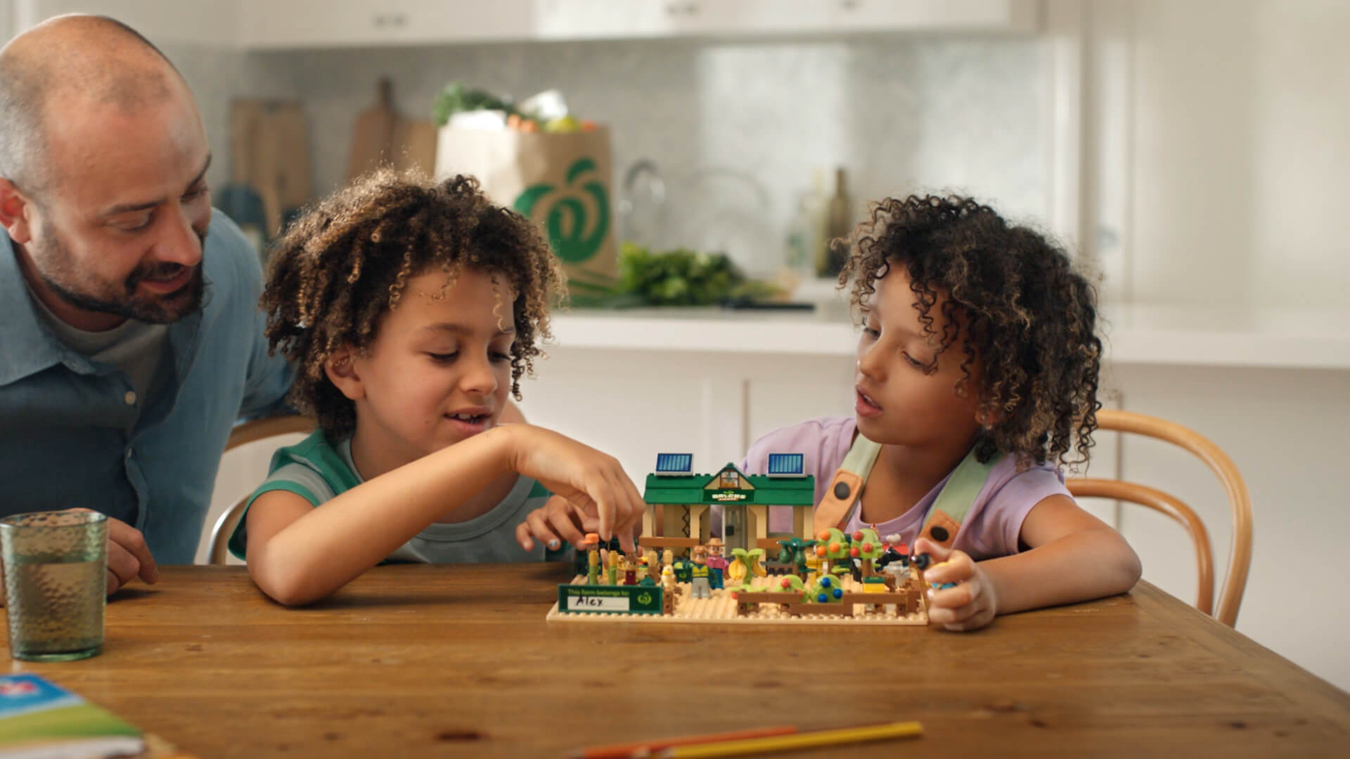 Image showing Woolworths Bricks Farm animation from television advertisement of two kids playing bricks at a kitchen table.